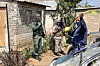 Soldater og en politioffiser ved sperret åsted utenfor en bygning i Johannesburg.