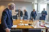 Granskingskommisjonen står samlet i et møterom på Stortinget med et stort bord foran seg.