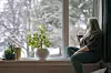 Bilde av kvinne som sitter i en vinduskarm og ser ut, med et glass i hånda. Foto: Gorm Kallestad/NTB