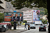 Fotgjengere går forbi store valgplakater for Demokratska fronta og HDZ BiH i en gate i Mostar.