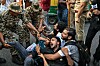 Sikkerhetspersonell holder fast flere demonstranter på gaten under en protest i New Delhi.