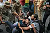 Sikkerhetspersonell holder fast flere demonstranter på gaten under en protest i New Delhi.