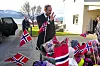 Kong Haakon vinker til en gruppe barn med norske flagg i Bjerkvik.