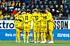 Bodø/Glimt-spillere i gule drakter samles i en ring på banen før andre omgang.