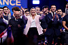 Eric Ciotti, Marine Le Pen og Jordan Bardella står på en scene omgitt av støttespillere.