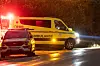 Gul ambulanse og politibil med blålys på en regnvåt vei i Ringerike om natten.