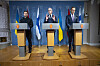 Volodymyr Zelenskyj, Jonas Gahr Støre og Alexander Stubb står ved talerstoler foran nasjonalflagg.