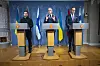 Volodymyr Zelenskyj, Jonas Gahr Støre og Alexander Stubb står ved talerstoler foran nasjonalflagg.
