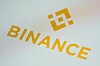 Binance-logo og oransje tekst på en lys smarttelefonskjerm.