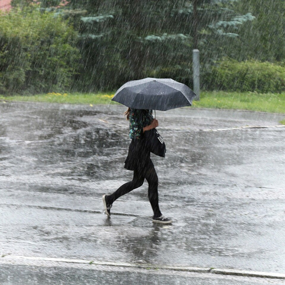 VÆR: Meteorologisk institutt har sendt ut gult farevarsel for styrtregn på Østlandet onsdag. Det meste av regnet vil falle i områdene øst for Oslo. Bildet viser en kvinne som løper i regnet med en paraply. Fra mandag ettermiddag til tirsdag morgen er det fare for både styrtregn, lyn og torden på Østlandet.