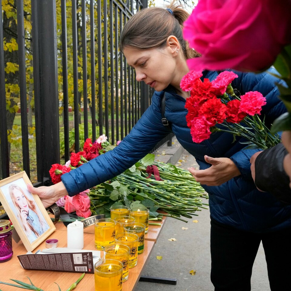 MARKERING: Folket i Perm minnes de døde etter skyting på universitetet. En kvinne setter et bilde av et av ofrene utenfor universitetet i Perm der seks personer ble drept mandag. Foto: Dmitri Lovetsky / AP / NTB
