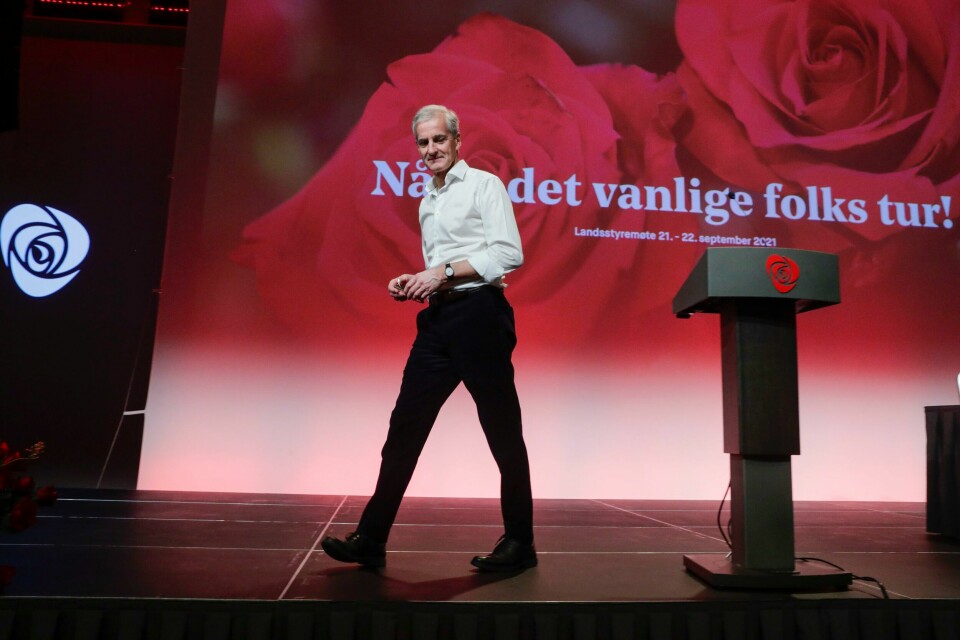 RASKT: Jonas Gahr Støre håper det går raskt å få startet regjerings-forhandlinger. Bildet er av Ap-leder Jonas Gahr Støre. Han går over en scene, vekk fra en talerstol. I bakgrunnen er en skjerm med røde roser og slagordet til Ap, om at «Nå er det vanlige folks tur». Støre har på svart bukse og hvit skjorte. Foto: Berit Roald / NTB