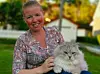 Maylen Asplund smiler til kameraet. Katten Melvin ligger på fanget hennes. Han er hvit, stor og hårete.
