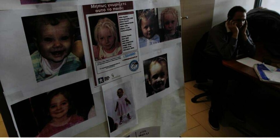 PLAKAT: En plakat med bilder av barn som er savnet henger på veggen til organisasjonen Barnets Smil. På plakaten er det også bilde av Maria. Gresk politi leter etter foreldrene hennes. Nå er enda et rompar i Hellas arrestert. De er mistenkt for å ha bortført et barn.