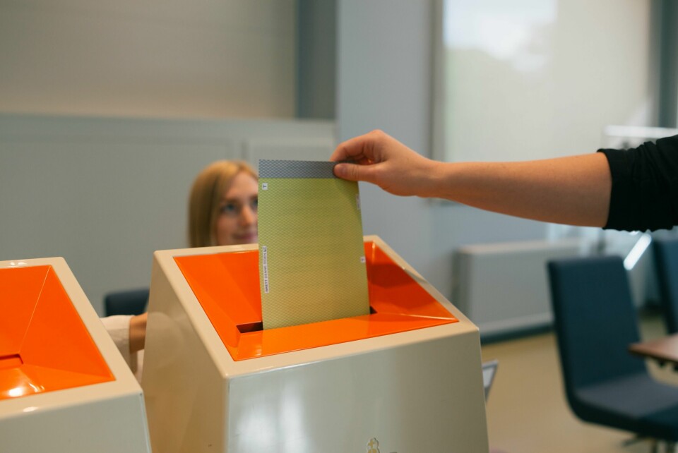 VALGURNE: Når stemmeseddelen er stemplet, kan du putte den i valgurnen. Bildet viser en person som putter en stemmeseddel i en valgurne.