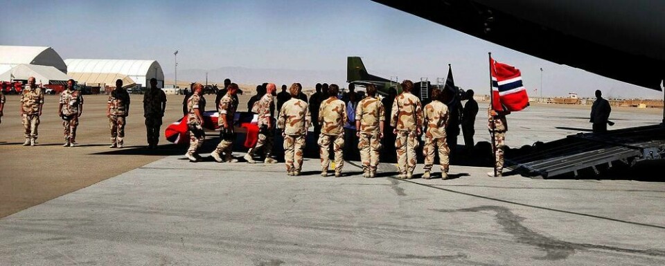 SEREMONI: Her blir kisten med Claes Joachim Olsson båret ombord i flyet hjem til Norge. Soldatene i Afghanistan kjemper videre. De har på dødning-hoder på uniformene og sier at de kjemper for kameraten sin. Det sjokkerer hjemme i Norge.