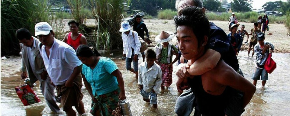 FLYKTER: Folk i Burma vasser over elver for å flykte fra kamper. Opprørere og soldater slåss.
