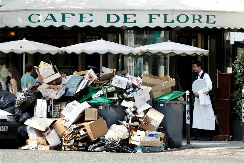 SØPPEL: Søppel har hopet seg opp utenfor en Café de Flore i Paris i Frankrike. Streik har ført til fulle søppelkasser og søppelhauger på gata.