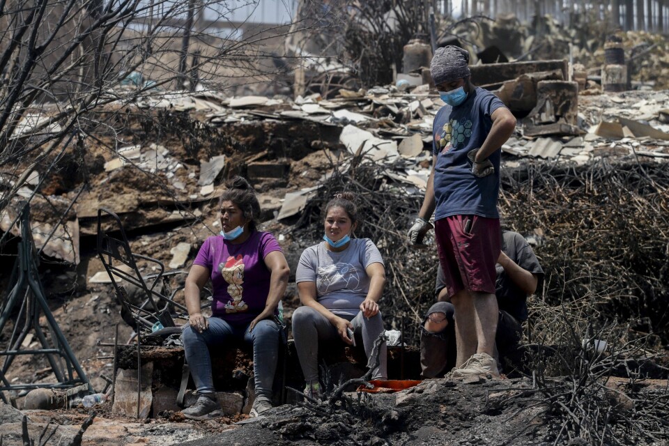 CHILE: Folk i Chile tar en pause mens de leter gjennom ruinene. Husene deres i Viña del Mar har brent ned. Lokale innbyggere tar en pause mens de leter gjennom ruinene av sine nedbrente hus i Viña del Mar søndag. Foto: Cristobal Basaure / AP / NTB