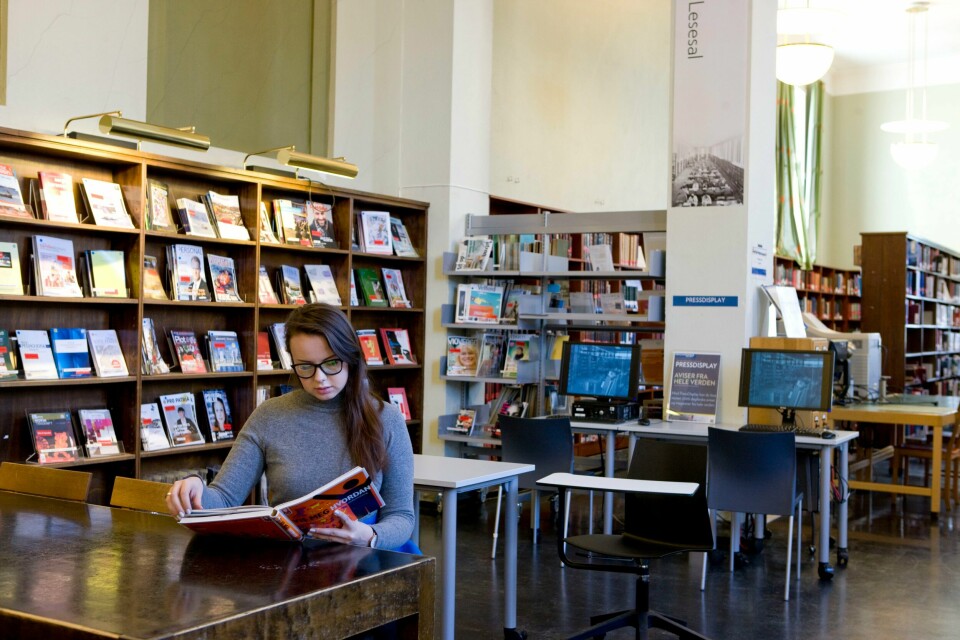 LIKESTILLING: Flere kvinner tar høyere utdanning enn menn, ifølge SSB. Bildet viser en kvinne som sitter og leser en bok i en lesesal.