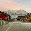 Bildet viser gata i Longyarbyen og et fjell i bakgrunnen.