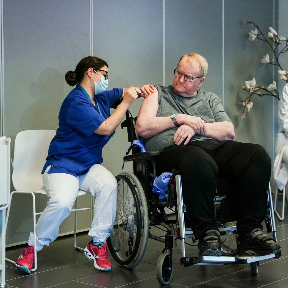 FØRST: Svein Andersen fikk den første dosen med vaksine. Sykepleier Maria Golding setter den.