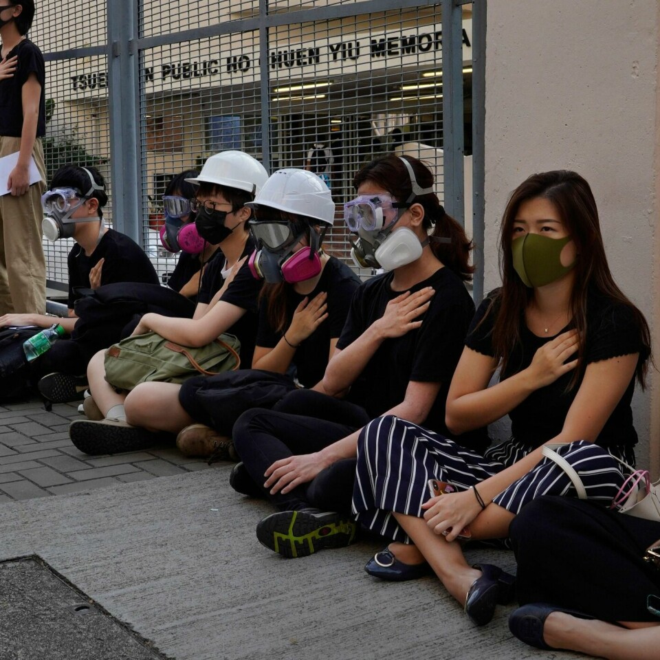SITTER: Her sitter folk i Hongkong i protest. Dagen før ble en tenåring skutt.