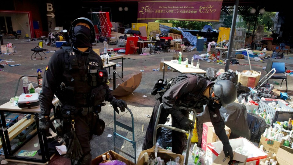 PROTESTER: Folk i Hongkong har protestert i flere måneder. Her rydder politifolk ved et universitet.