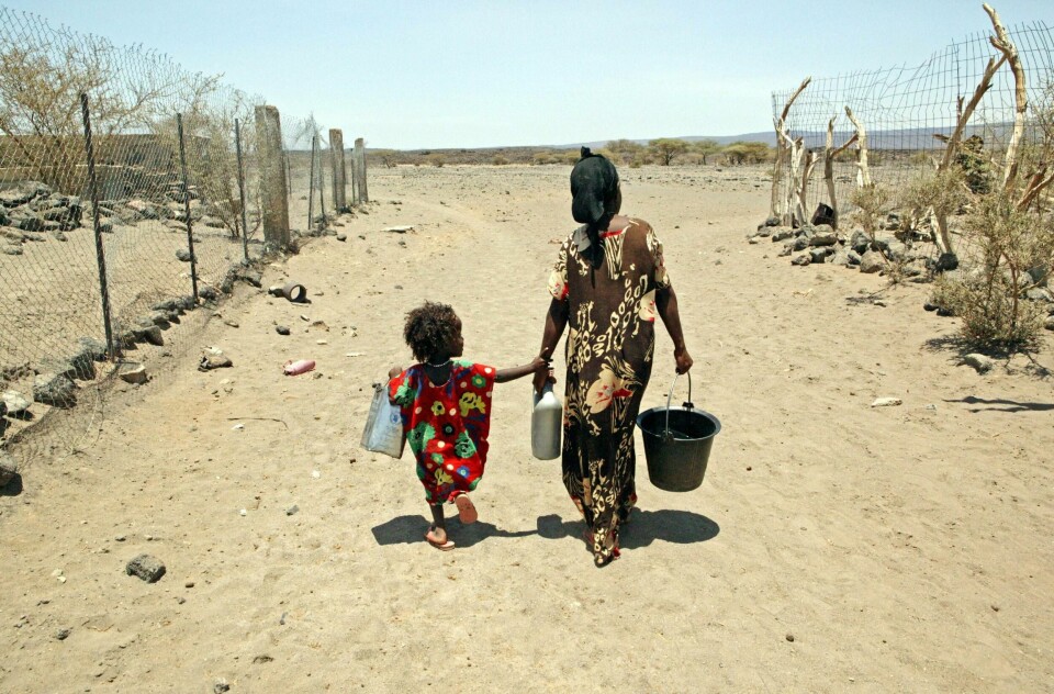 FATTIG: En gravid kvinne med et barn går den lange veien for å hente vann i Djibouti. Mange fattige land i Afrika har dårlige systemer for vann. Det er ett av problemene utviklings-fond jobber med.
