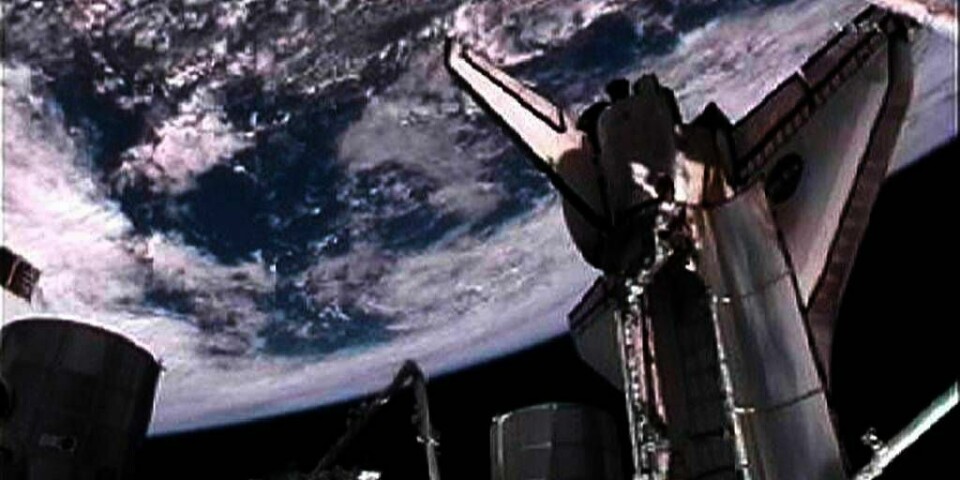 ROMMET:  Romfergen Atlantis er tilkoblet romstasjonen ISS. Du kan se jorda i bakgrunnen. Bildet er tatt av den amerikanske romfarts-organisasjonen NASA søndag.
