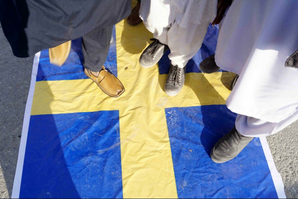 SVERIGE: For første gang har noen blitt dømt for koranbrenning i Sverige. Bildet viser folk som står på det svenske flagget.