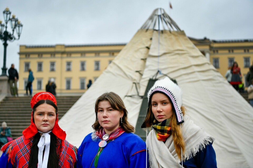 FOSEN-AKSJONEN: Elle Nystad, Elle Rávdná Näkkäläjärvi og Ella Marie Hætta Isaksen er på Slottsplassen. Der har Fosen-aksjonistene har satt opp en lavvo. De ber om å få møte kong Harald. Bildet viser Fosen-aksjonistene Elle Nystad, Elle Rávdná Näkkäläjärvi og Ella Marie Hætta Isaksen foran slottet i Oslo.