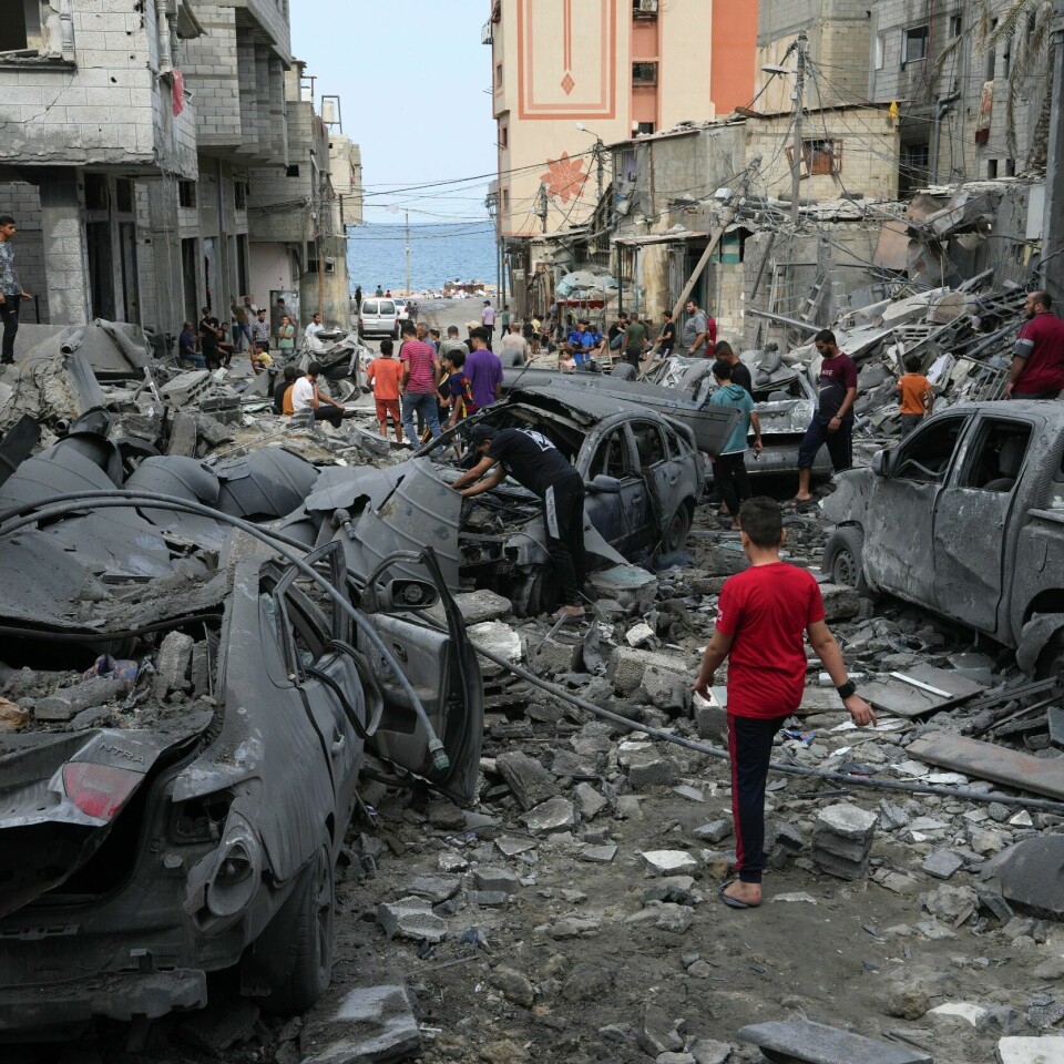 KRIG: En moské er ødelagt etter angrep i byen Gaza mandag morgen. En palestinsk gutt går gjennom en gate i flyktningleiren Al Shati på Gazastripen etter et rakettangrep mandag morgen. Foto: Adel Hana / AP / NTB