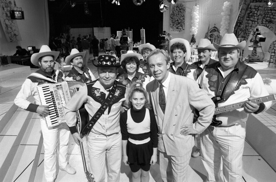 1990: Redd Barna fikk penger fra TV-aksjonen også i 1990. Her er programleder Petter Nome sammen med artister. Bildet viser programleder Petter Nome sammen med artister.