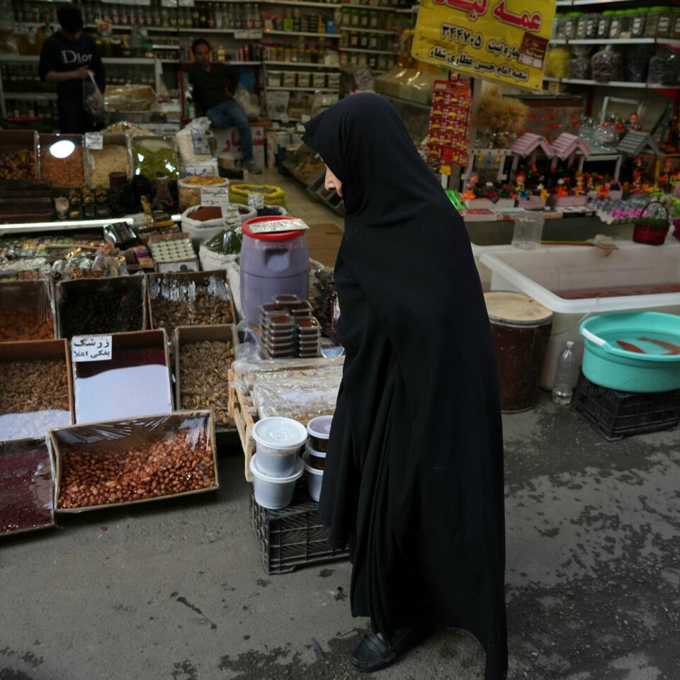 IRAN: Iranske kvinner må dekke til håret når de utenfor hjemmet sitt. Det sier iranske lover. En eldre kvinne går gjennom en lokalt marked i Irans hovedstad Teheran. Siden september har minst 537 demonstranter blitt drept i uro i landet, ifølge menneskerettighetsgruppa Iran Human Rights. Foto: Vahid Salemi / AP / NTB