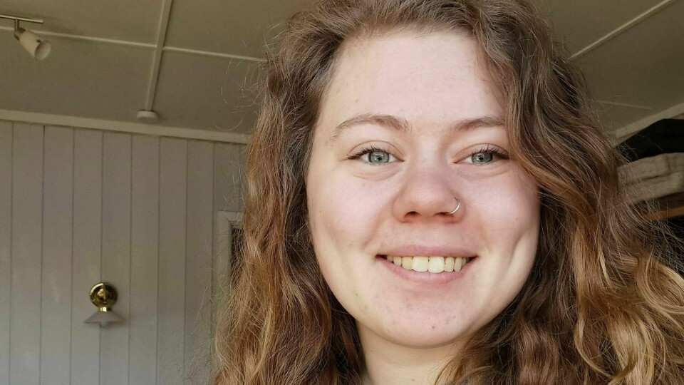 I JOBB: Irja Marie Eide Mølmen er døv og har fibromyalgi. Hun har endelig funnet en jobb som gir henne energi. Irja Marie Eide Mølmen smiler til kamera. Hun har store krøller og har på seg en grå genser.
