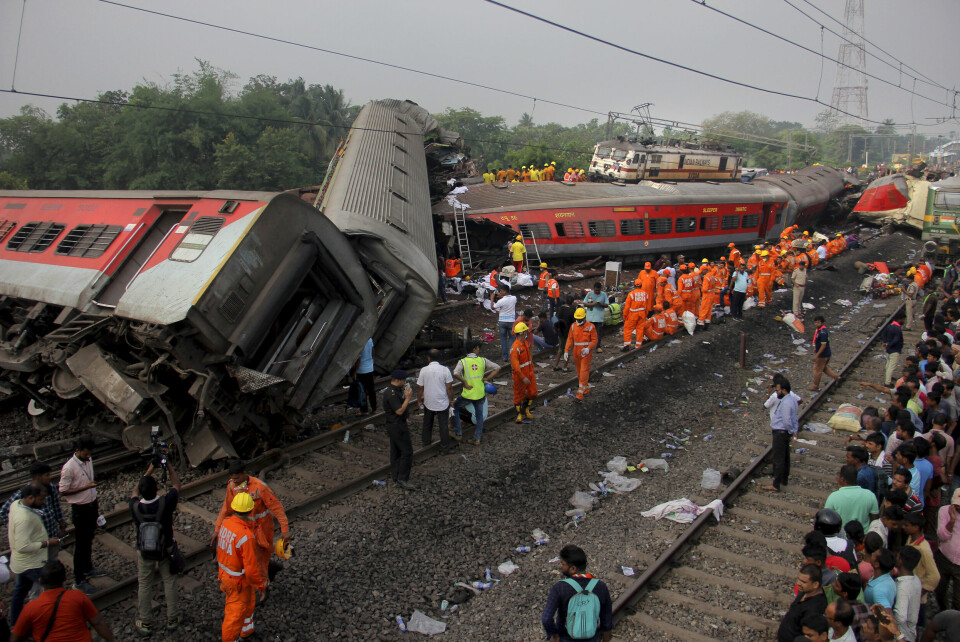 OVERLEVENDE: Noen overlevde ulykken. Men etter få timer hentet redningsfolk ut lik. Redningsarbeidere på stedet der to tog var involvert i en massiv avsporing og kollisjon i den østlige delstaten Odisha i India lørdag. Foto: AP/NTB