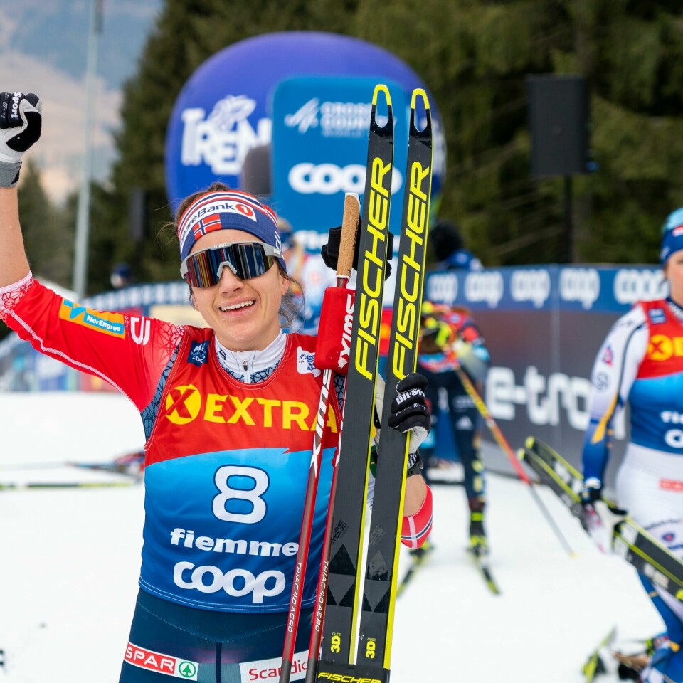 VANT: Heidi Weng kunne juble for seier i siste løp av Tour de Ski. Det gjør at hun blir nummer tre sammenlagt. Bildet er av skiløperen Heidi Weng som jubler for en seier. Flere andre skiløpere går ved siden av eller sitter i bakgrunnen. Weng har løftet en arm i været og smiler. Hun har på solbriller. Foto: Terje Pedersen / NTB