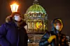 Bildet viser to personer med munnbind foran en katedral i St.Petersburg.