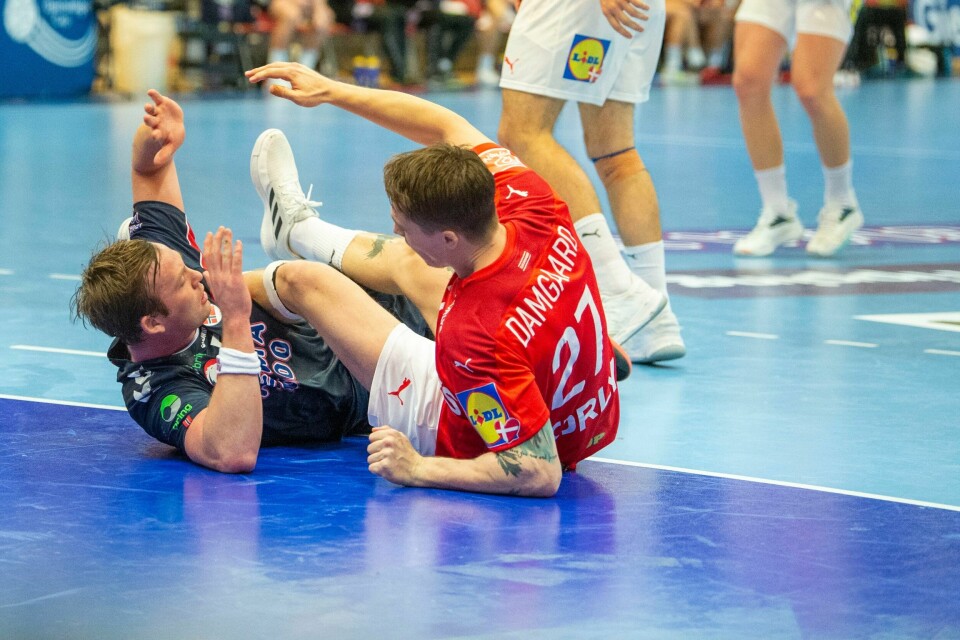 REGLER: Nye smitteregler kan føre til vansker for håndball-EM, mener en dansk ekspert. I verste fall kan det bety at mesterskapet må bli avlyst. Da mister både Norge og Danmark miste muligheten for gull. Bilder er av håndballspillere som ligger på parketten etter en duell. Det er Norges Sander Sagosen og Danmarks Michael Damgaard Nielsen.