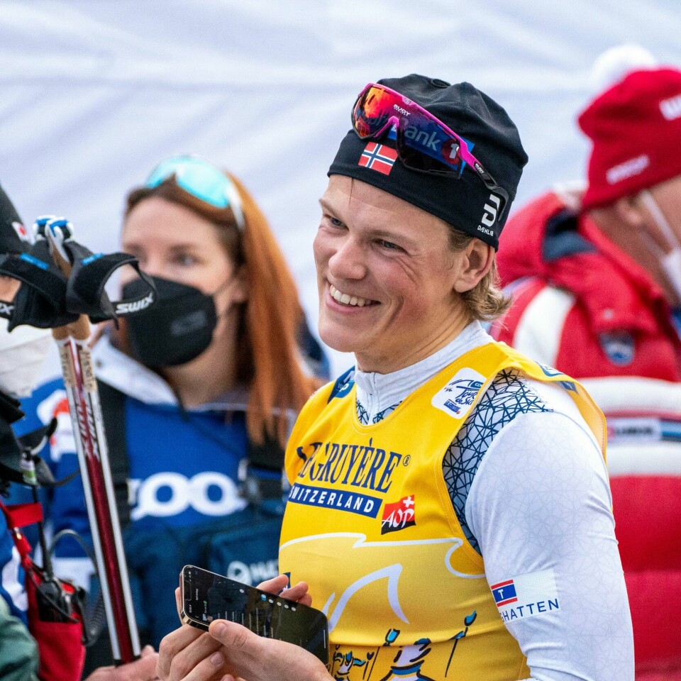 VANT: Johannes Høsflot Klæbo smilte bredt etter at han vant Tour de Ski sammenlagt i år. Bildet er av Johannes Høsflot Klæbo i skiutstyr. Han smiler bredt etter å ha vunnet Tour de Ski. Det står mye folk i bakgrunnen, både med og uten munnbind. Foto: Terje Pedersen / NTB
