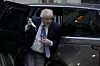 Bildet er av Boris Johnson på vei ut av en bil. Han er i ferd med å ta på seg et munnbind. Foto: Alastair Grant / AP / NTB