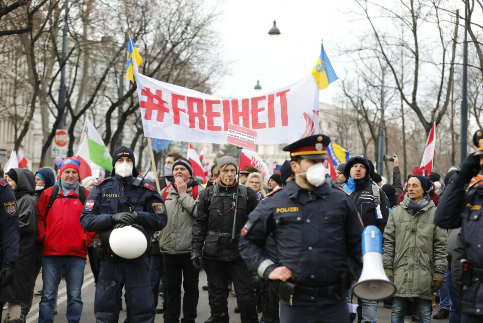 People take part in a demonstration against the country's coronavirus restrictions holding a sign that says „freedom' in Vienna, Austria, Saturday, Jan. 8, 2022. (AP Photo/Lisa Leutner) 40.000 mennesker demonstrerte i Wien lørdag i protest mot myndighetenes koronatiltak. Foto: Lisa Leutner / AP / NTB
