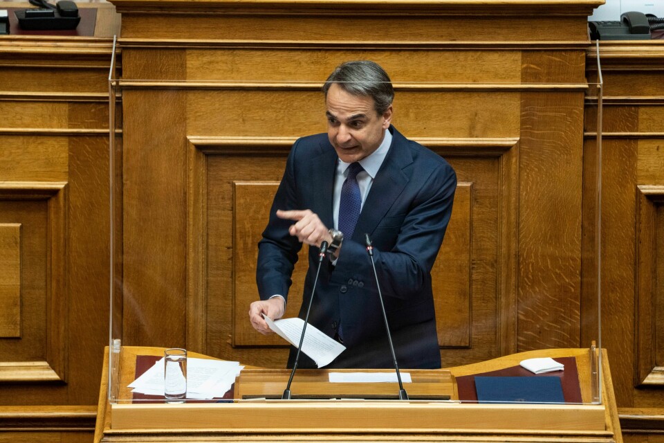 FORSVAR: Den greske statsministeren mener landet må kjøpe flere fly for å forsvare øyene nær Tyrkia. Bildet er av Kyriakos Mitsotakis, som er statsminister i Hellas. Han står på en talerstol, med glass rundt seg.. Foto: Petros Giannakouris / AP / NTB
