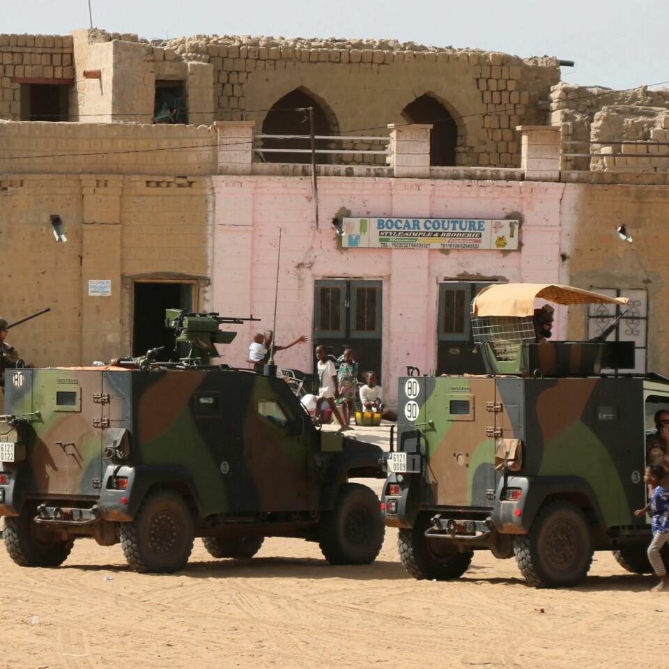 REISER: Franske soldater har vært i Mali i mange år. Nå blir de hentet hjem eller sendt til andre områder i Sahel. Bildet er av franske soldater i biler. De er ute på patrulje i Timbuktu i Mali. Bilene står på en åpen plass foran murbygg. Det er sand på bakken. Foto: Moulaye Sayah / AP / NTB