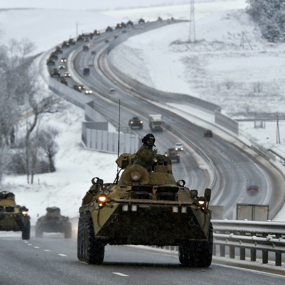ØVELSE: Russland har hatt øvelse for militæret de siste ukene. Flere av dem har øvd på Krim-halvøya. Det har ført til at mange har vært redde for at Russland gjorde seg klare for en krig mot Ukraina. Bildet er av russiske militærkjøretøy som kjører på en bilvei på Krim-halvøya. Det er lang kø av vanlige biler bak dem. Nesten alle skal i samme retning. Bildet er fra 12. januar i 2022. Foto: AP / NTB