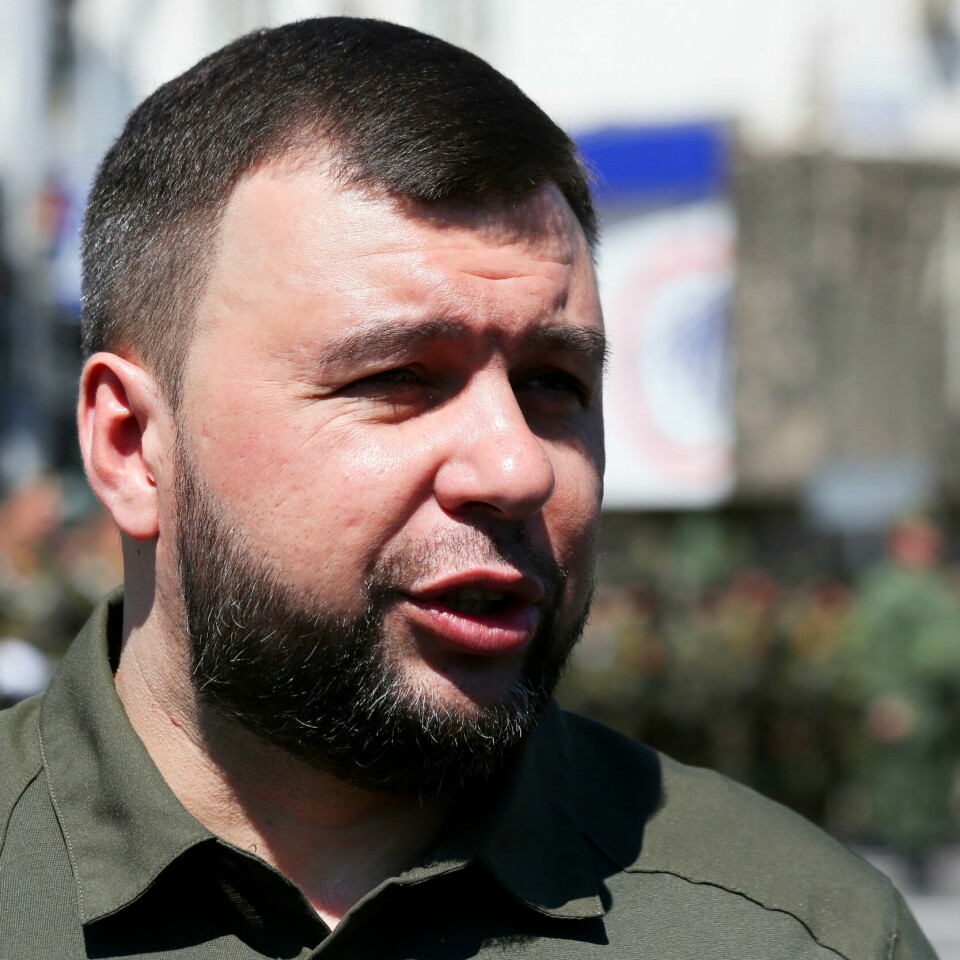 EVAKUERER: Sivile i Donetsk skal bli sendt bort, sier Denis Pusjilin. Kvinner, barn og eldre får reise først. Bildet er av Denis Pusjilin. Han har kort hår og skjegg. Han er iført grønne klær. Det er en militærparade i bakgrunnen. Arkivfoto: Alexei Alexandrov / AP / NTB