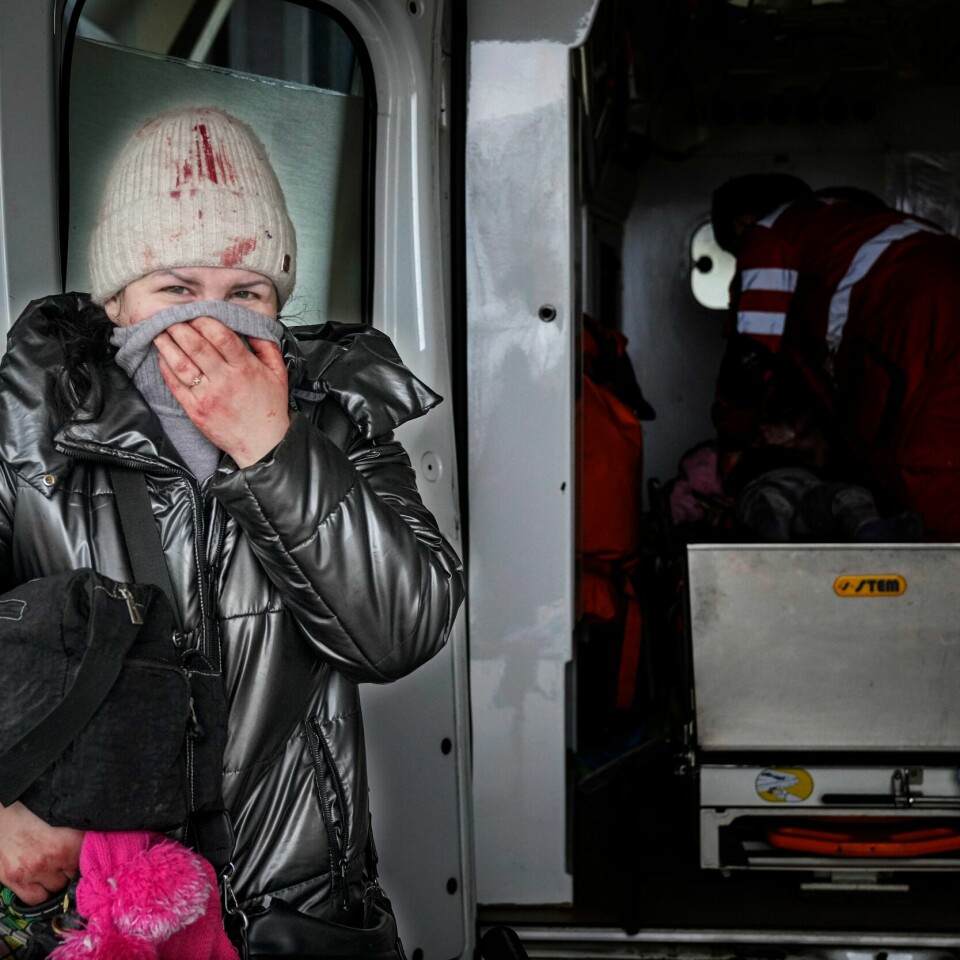 SØRGER: En mor står ved en ambulanse. Inne i ambulansen kjemper flere for å redde dattera på seks år. Hun dør etter hvert. Til orientering: Bildet er noe mørknet i bakgrunnen. Bildet viser en mor som gråter utenfor en ambulanse.