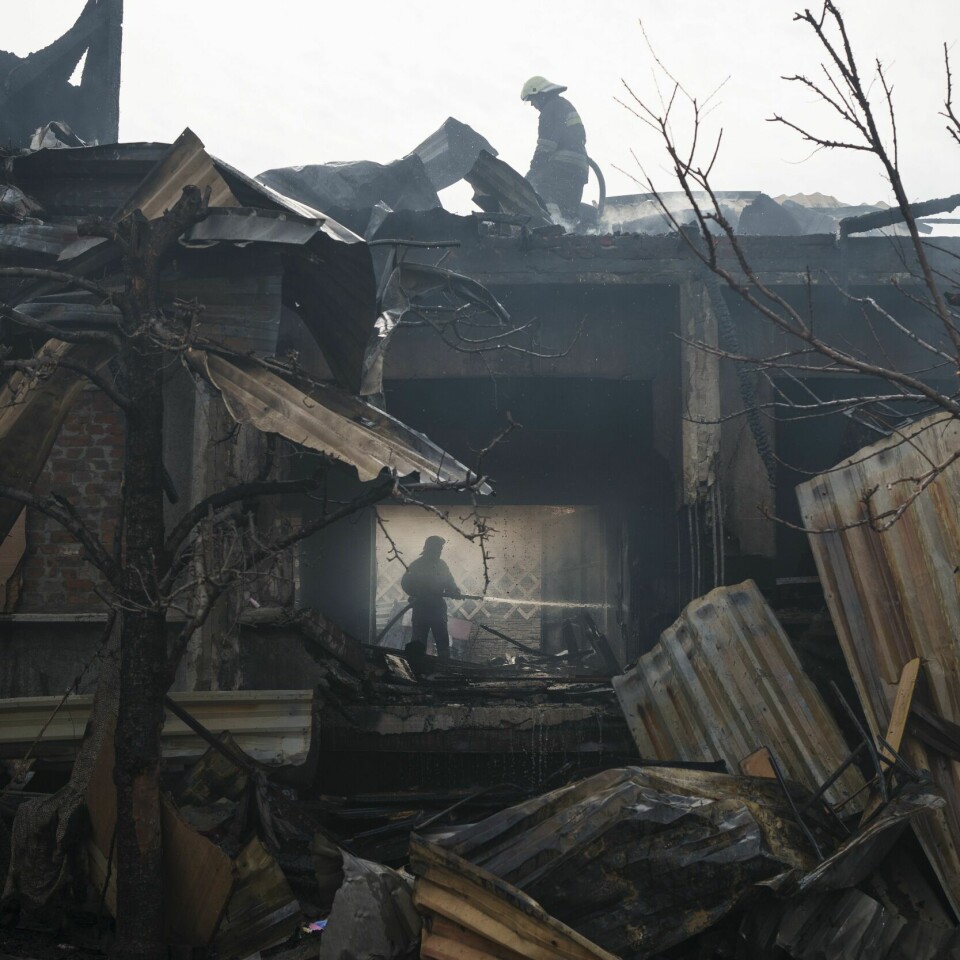KRIG: Brannmenn må slukke en brann i et hus i Kharkiv. Krigens ødeleggelser i Ukraina har vidtrekkende konsekvenser for hele verden, som opplever mangel på mat og andre varer og økte prisnivåer. Her fra et russisk angrep mot den ukrainske byen Kharkiv. Foto: Felipe Dana / AP /NTB