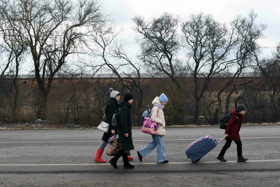 FAMILIE: En ukrainsk familie drar fra hjemlandet. De er på vei mot Polen etter angrepene fra Russland. Bildet viser en ukrainsk familie som går mot grensa til Polen.
